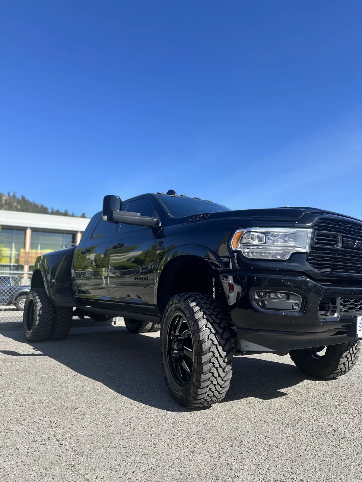 Lifted black Ram truck outside the Kelowna Details shop under a blue sky